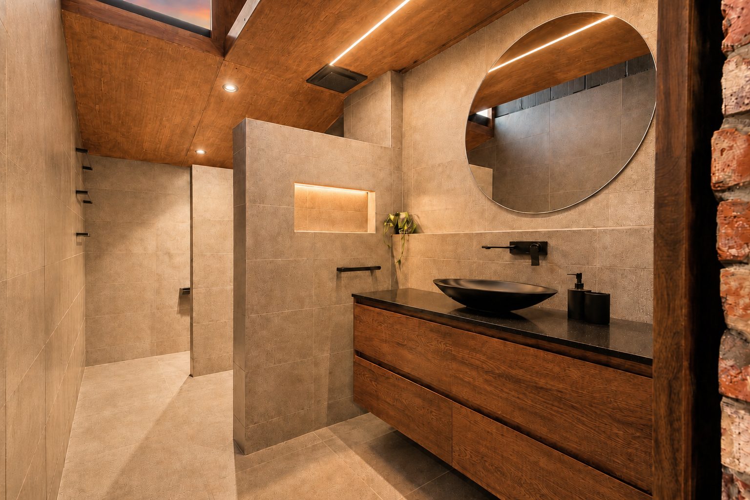 The Midnight Hideaway – warm stone bathroom with black fixtures and timber ceiling